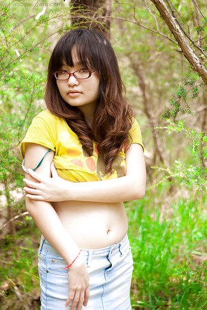 Petite Asian girl in glasses bares hairy vagina outdoors after slow strip